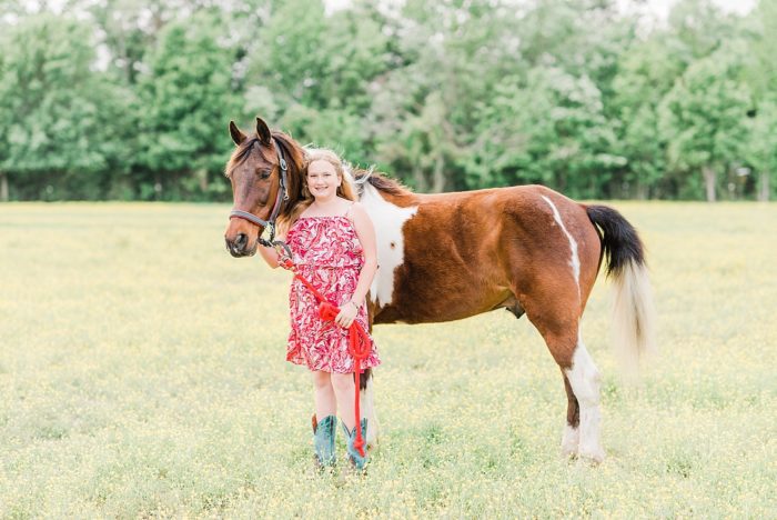 girl with spotted saddle horse in a field of buttercups