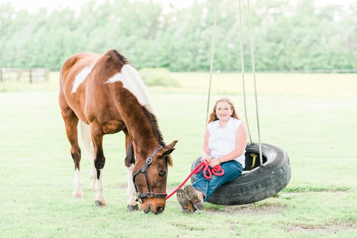 a girl and her horse hanging out by the tire swing