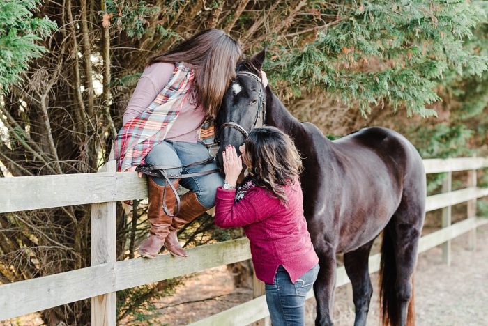 mom and daughter kissing horse